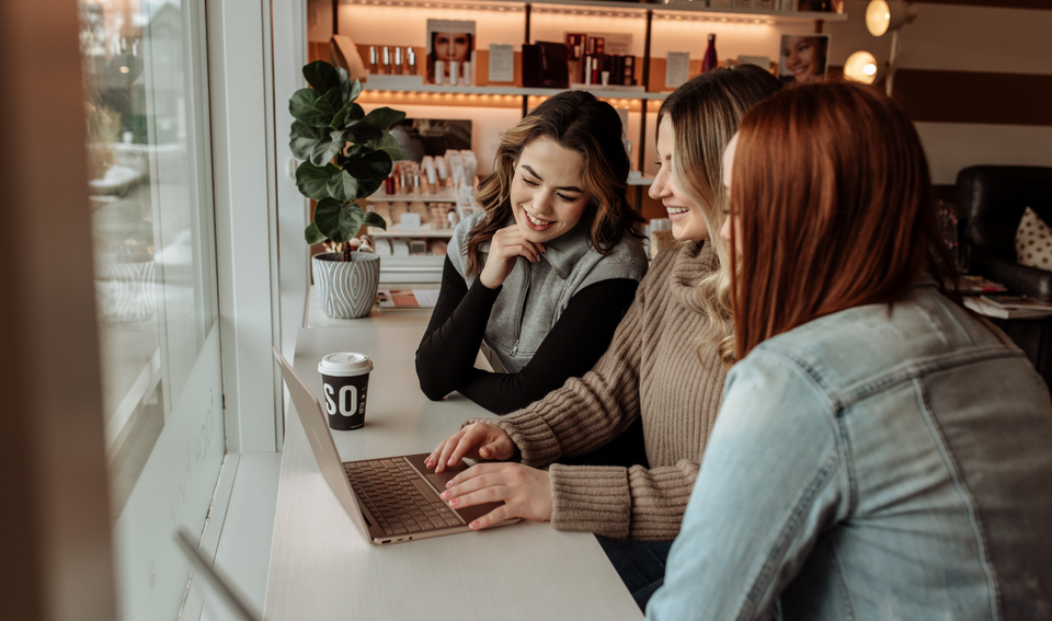 Women go over financing options on laptop at Flirt Cosmetics Studio Medical Spa